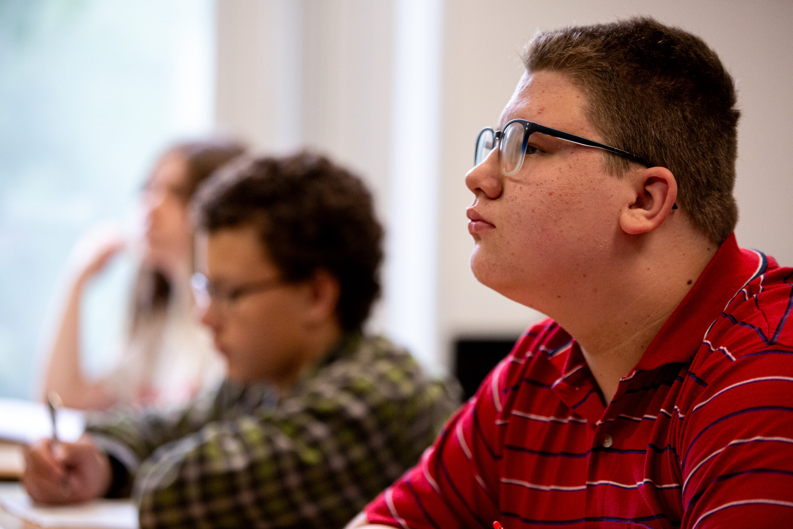 Man in glasses listens attentively during a meeting